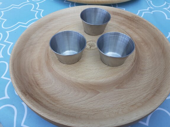 Person cleaning and oiling wooden kitchenware on a worktop