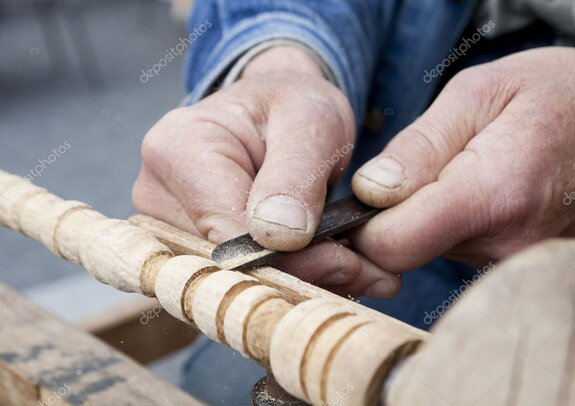 Woodturner shaping a bowl on the lathe in a workshop